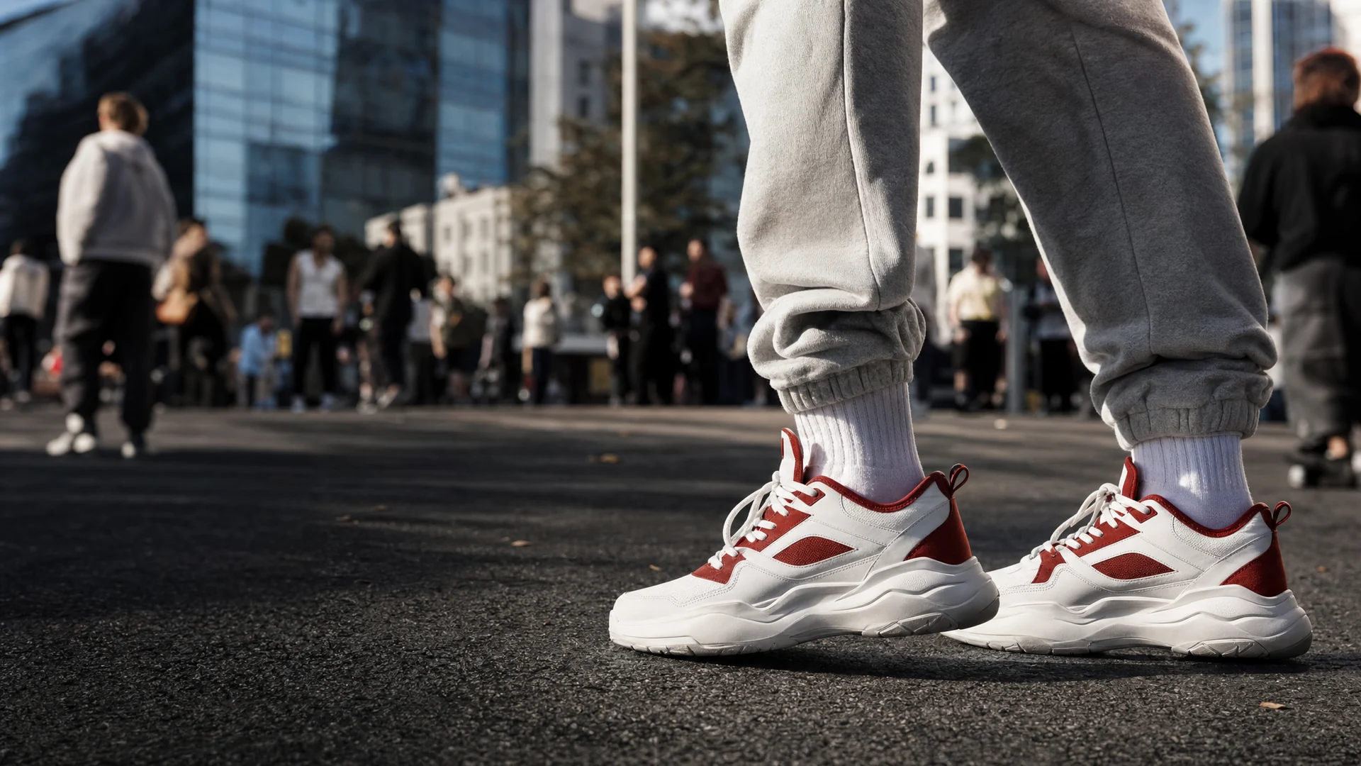 White and red running trainers mid-stride on a city pavement.